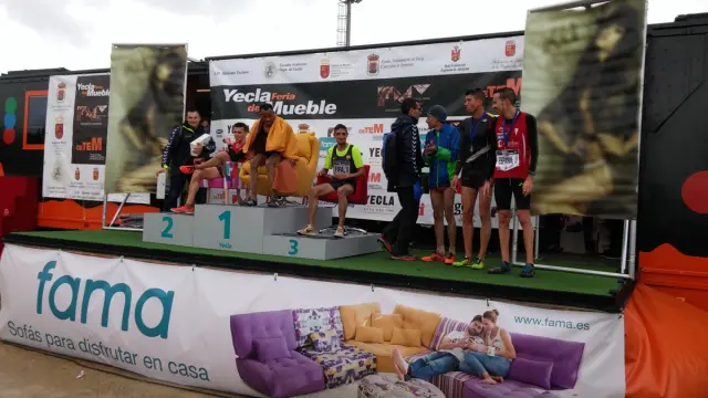 First podium with the athletes sitting on armchairs.