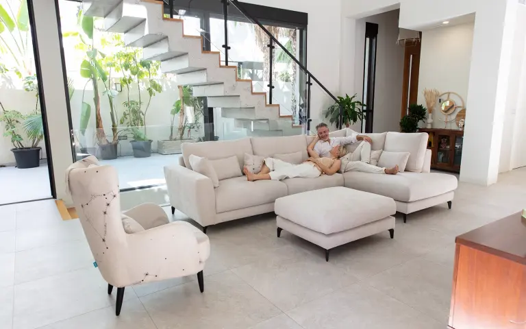 Sofá con tela Astral, tejido decorativo y confortable aplicado en sofá y cojines en salón moderno.