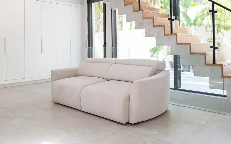 Sofá compacto tapizado en tela Astral, tejido versátil y confortable en color neutro para espacios actuales.